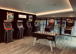 Arcade room with vintage arcade machines and a foosball table.